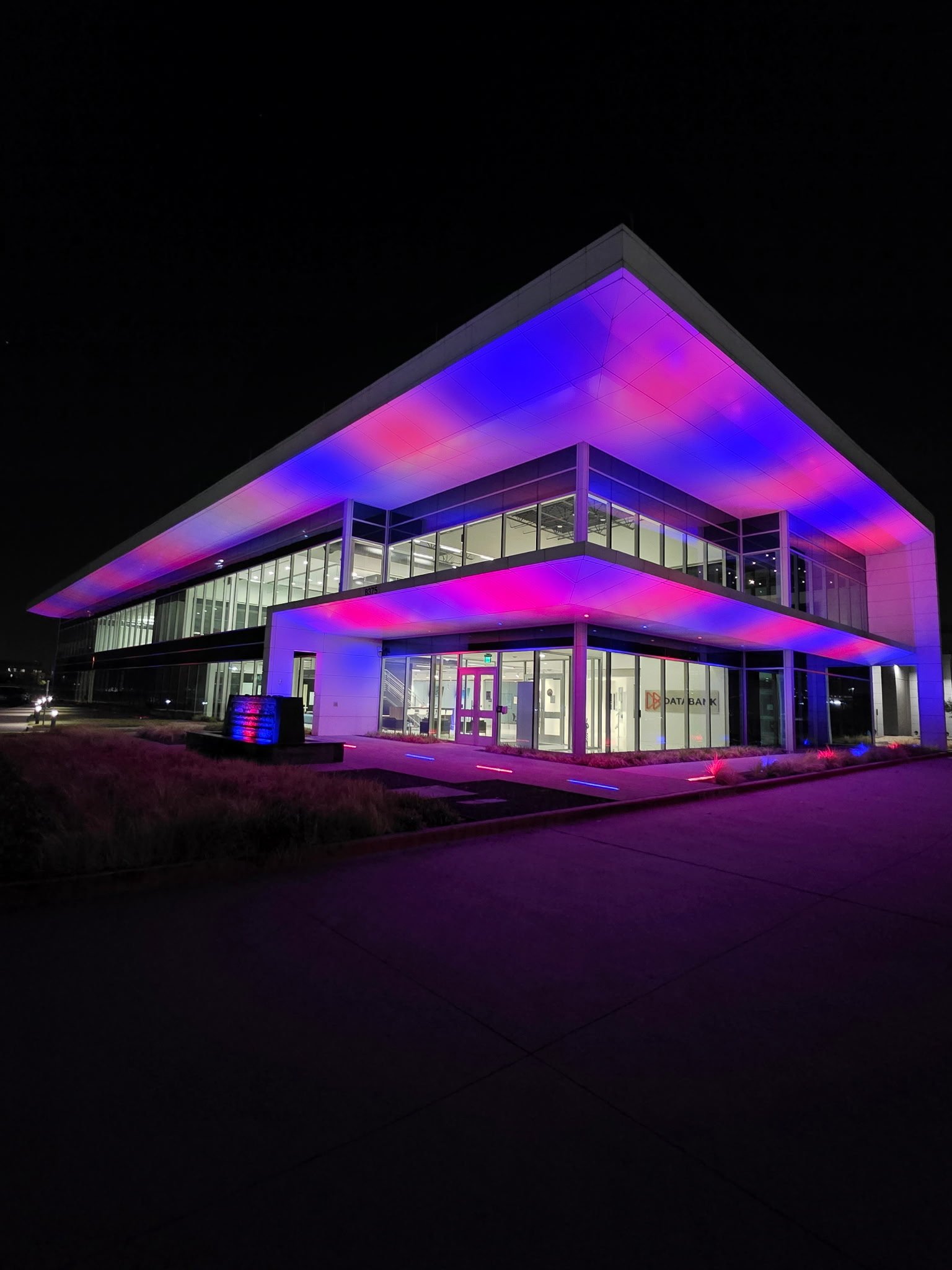 Commercial data-center canopy and facade illuminated by architectural color lighting