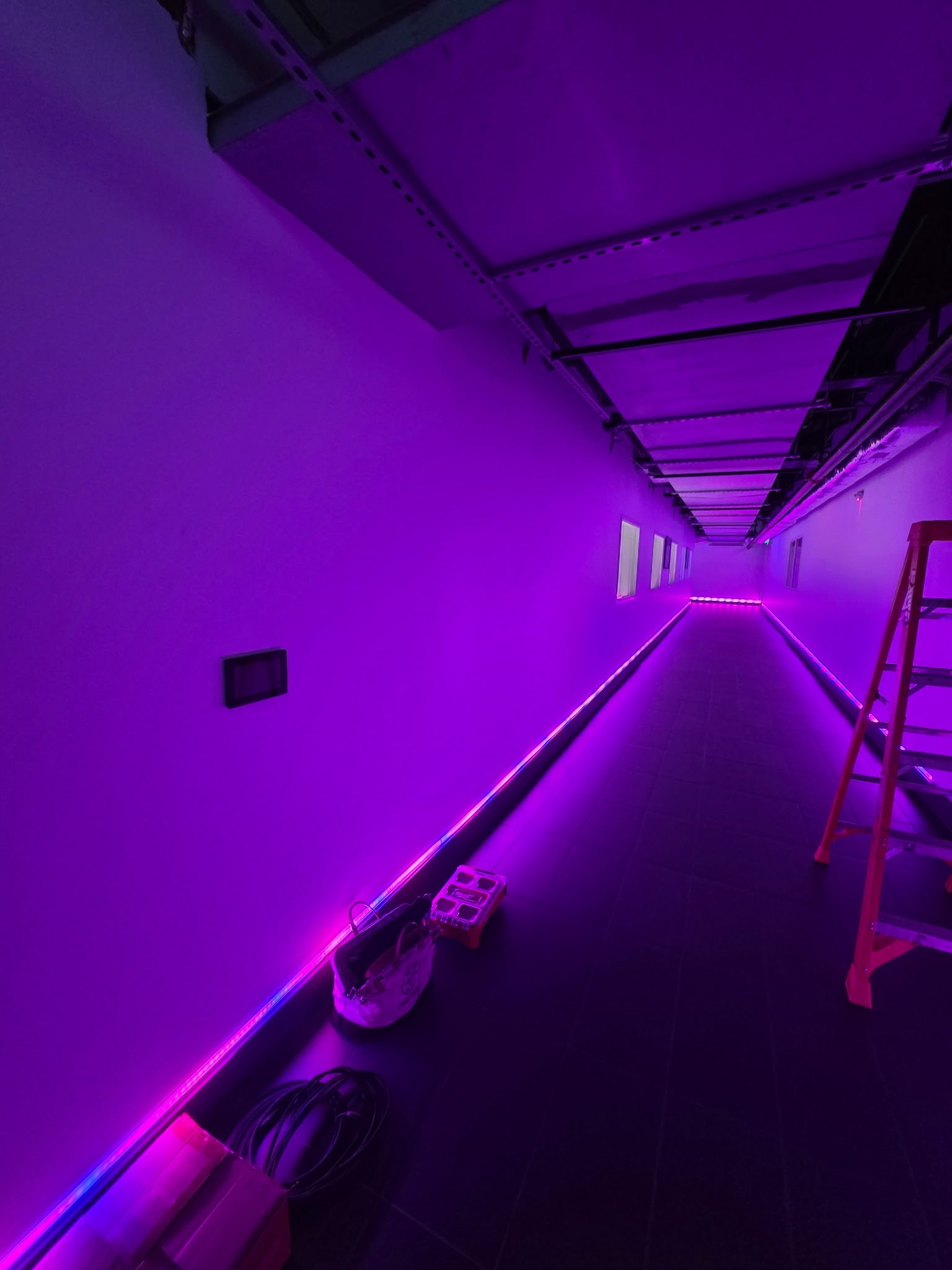 DMX RGBW linear lighting illuminating a commercial data-center corridor in purple