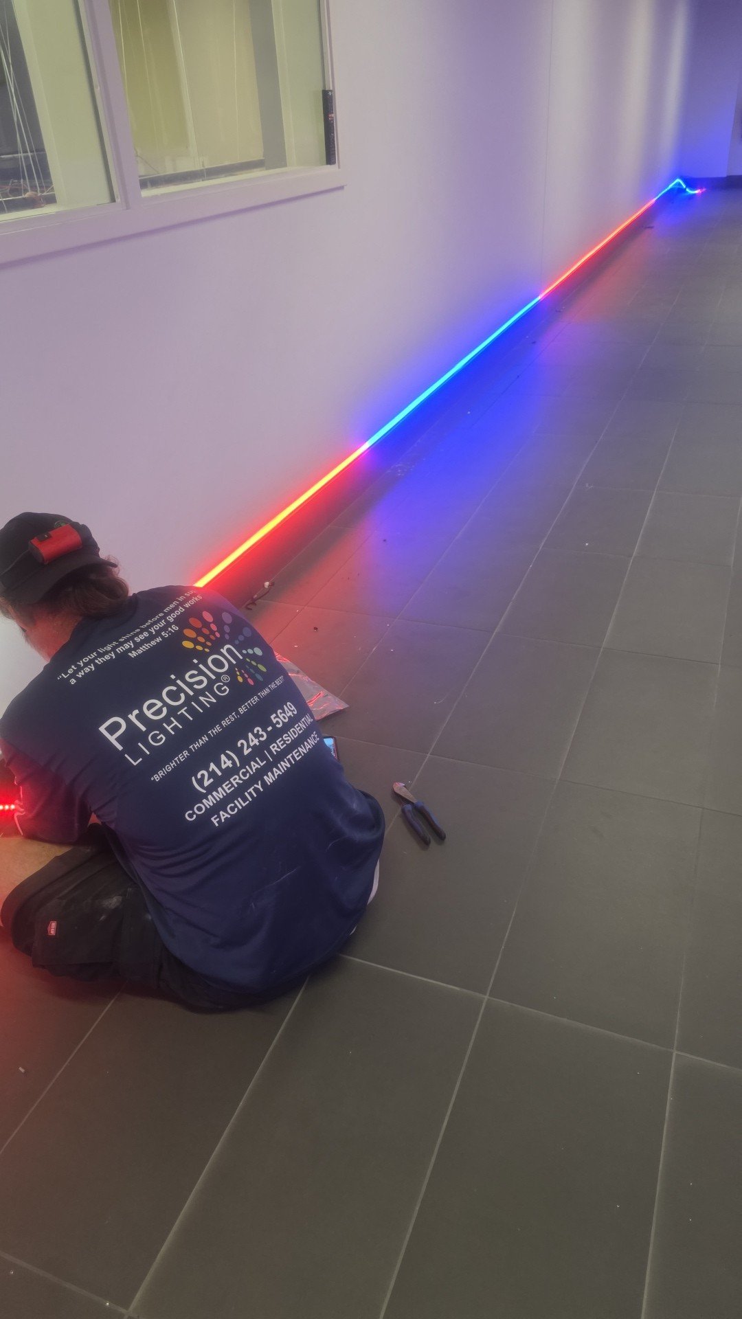 Precision Lighting technician installing DMX RGBW linear lighting in a commercial data-center corridor
